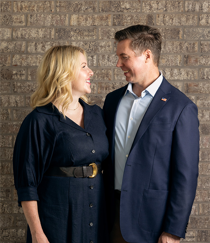 Adam Pugh and his wife smiling at one another