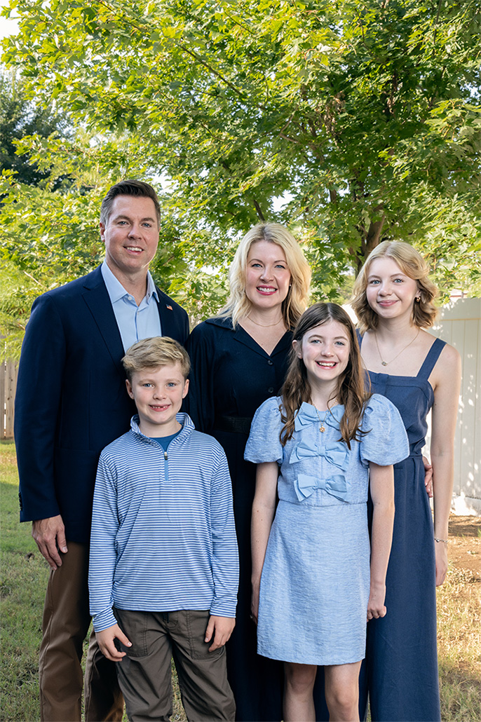 Adam Pugh, his wife, and their three children standing outside
