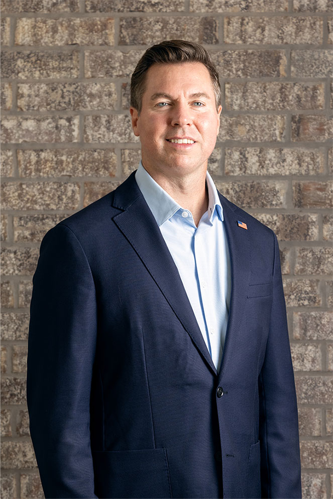 Republican Adam Pugh standing in front of a brick wall