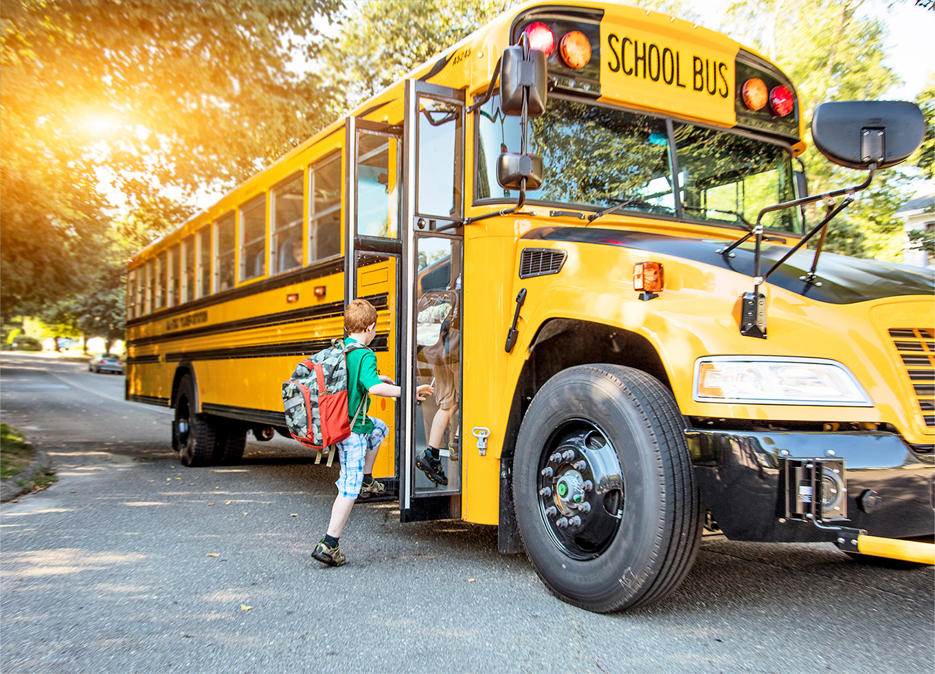 Elementary students stepping onto a school bus